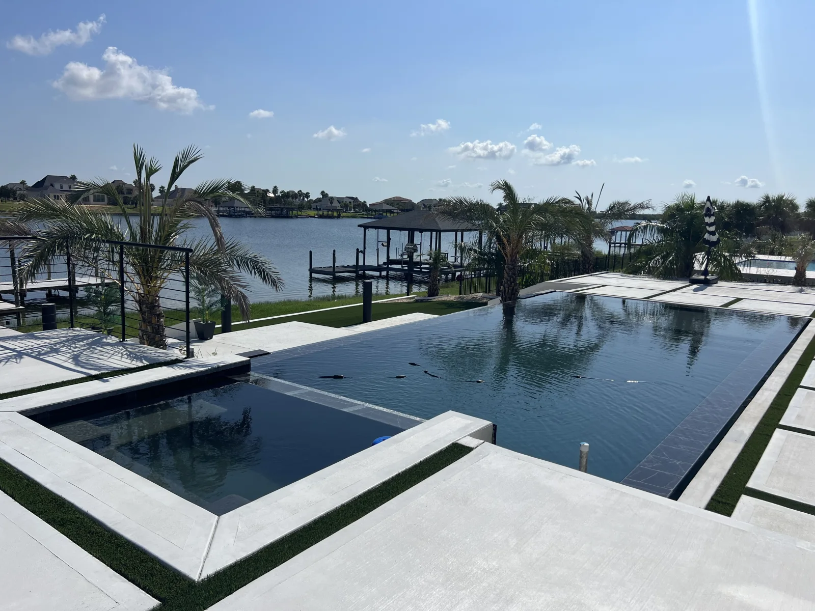 Completed custom pool and spa overlooking the water in a Cypress Pools & Outdoors project