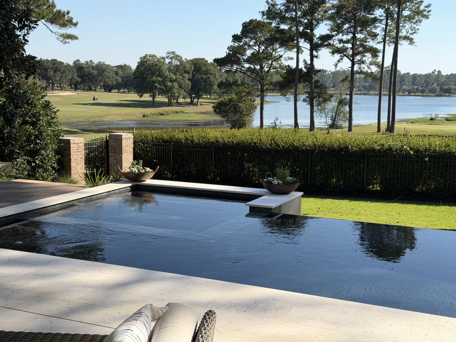 Custom pool and patio overlooking a lake in a Cypress Pools & Outdoors project